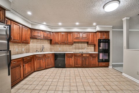 A kitchen with wooden cabinets and black appliances.