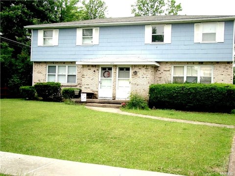 A blue house with a white door and windows.