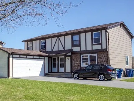A house with a car parked in front.