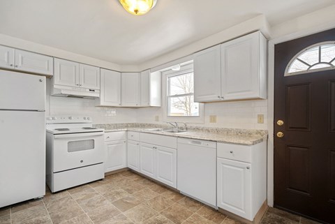 A kitchen with white appliances and cabinets.