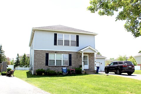 A house with a blue car parked in front.