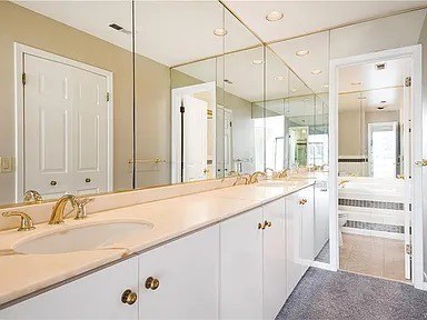 A bathroom with a white sink and a large mirror.