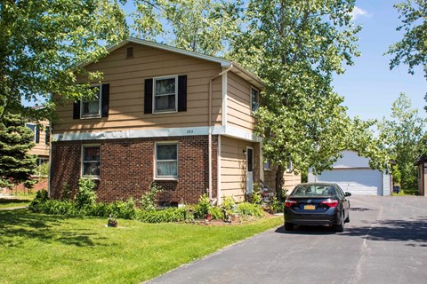 A house with a car parked in front.