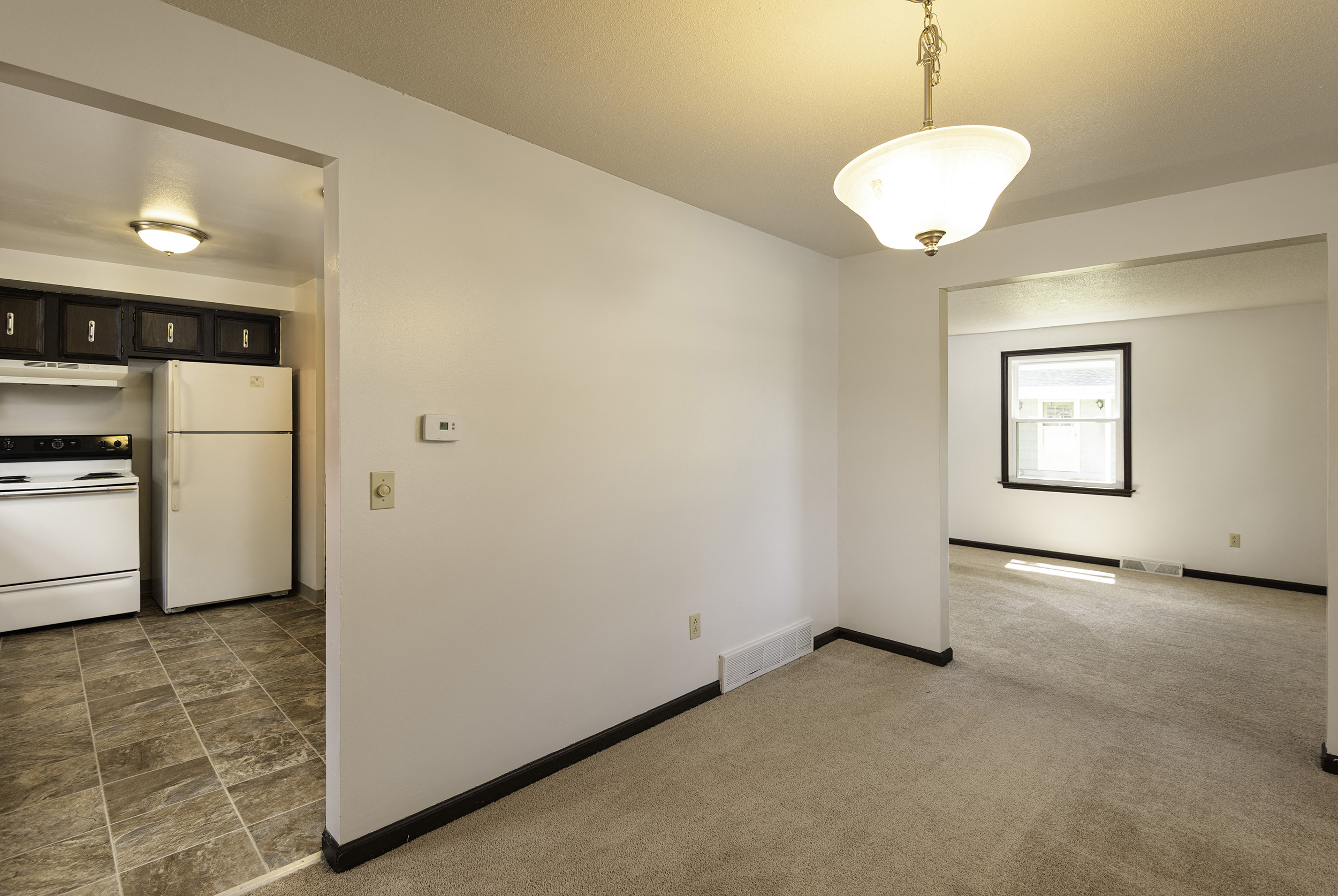 A kitchen with white appliances and a small framed picture on the wall.