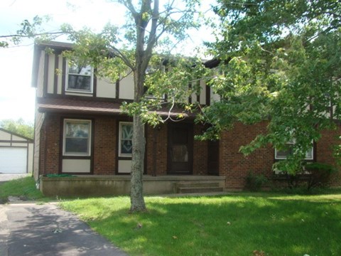 A house with a tree in front of it.