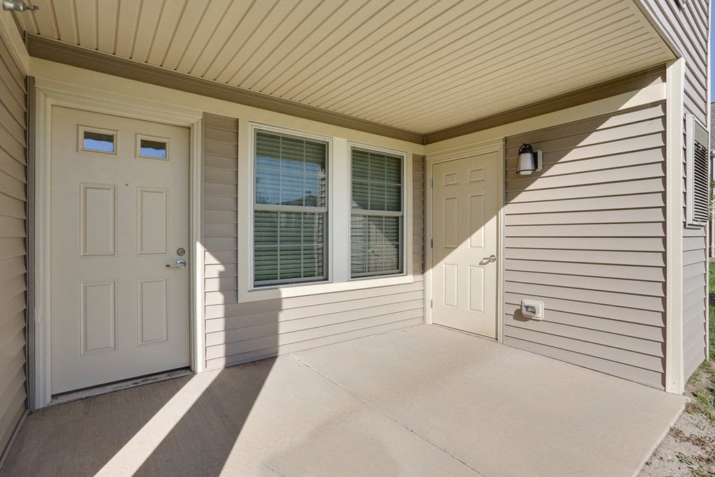 the front porch of a home with a white door