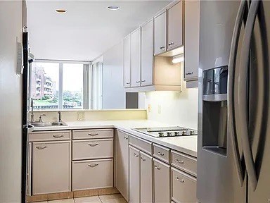 A kitchen with white cabinets and appliances.