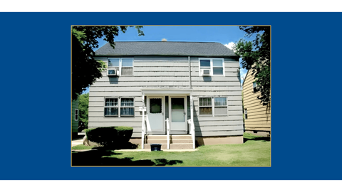 A two-story house with a front porch and a white door.