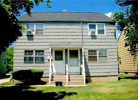 A grey house with a white door and windows.
