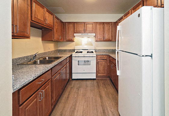 A kitchen with wooden cabinets and a white refrigerator.