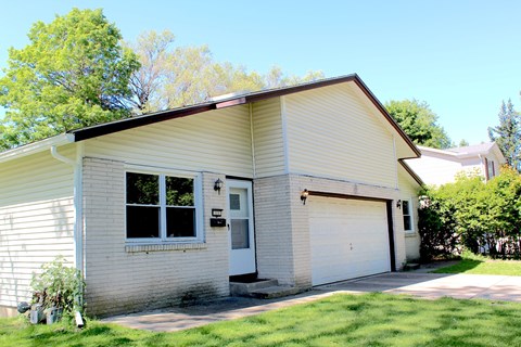 A house with a white garage door and a brown roof.