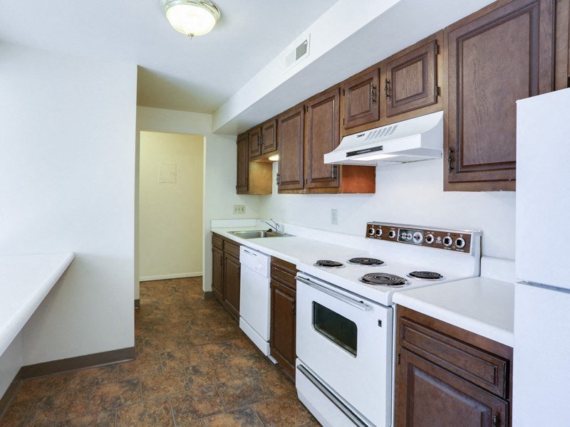 a kitchen with white appliances and wooden cabinets