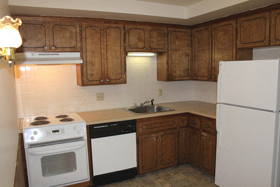 A kitchen with wooden cabinets and a white refrigerator.