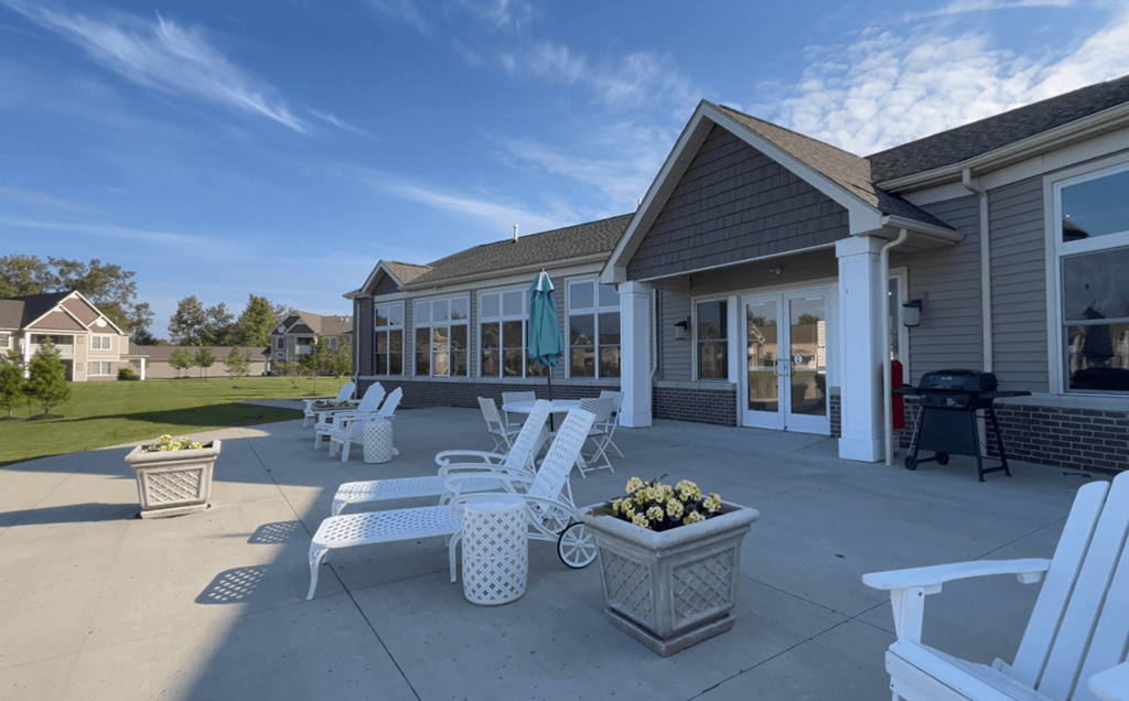 a patio with chairs and tables in front of a building