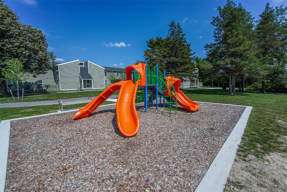 A playground with a slide and a climbing structure.