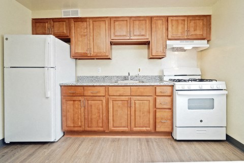 A kitchen with wooden cabinets and white appliances.