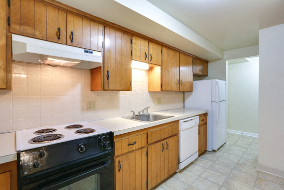 A kitchen with wooden cabinets and a black stove top oven.