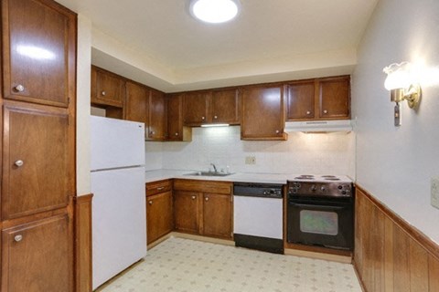 A kitchen with wooden cabinets and a white refrigerator.