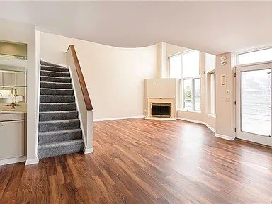A living room with a fireplace and a staircase.