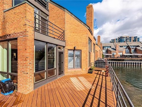 A building with a wooden deck overlooking a body of water.