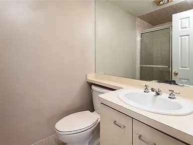 A white toilet sits next to a sink in a bathroom.