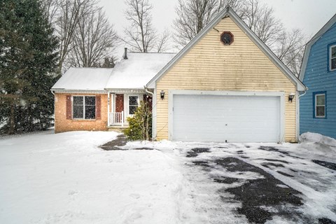 A house with a white garage door in the snow.