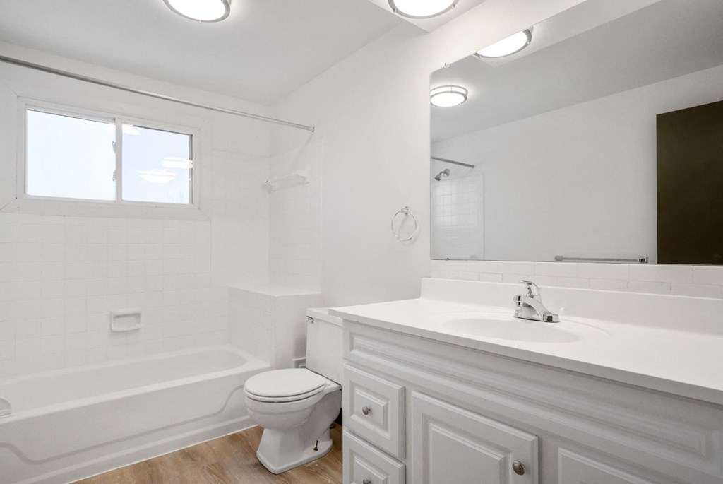 A white bathroom with a toilet, sink, and tub.