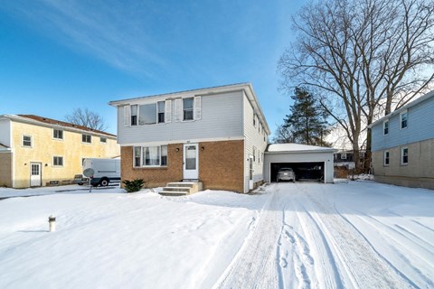 A house with a driveway covered in snow.