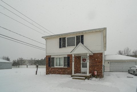 A house with a snowy front yard.