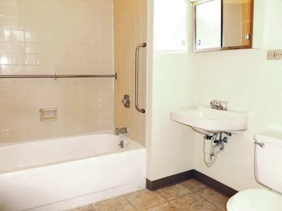 A white bathroom with a tub, sink, and toilet.