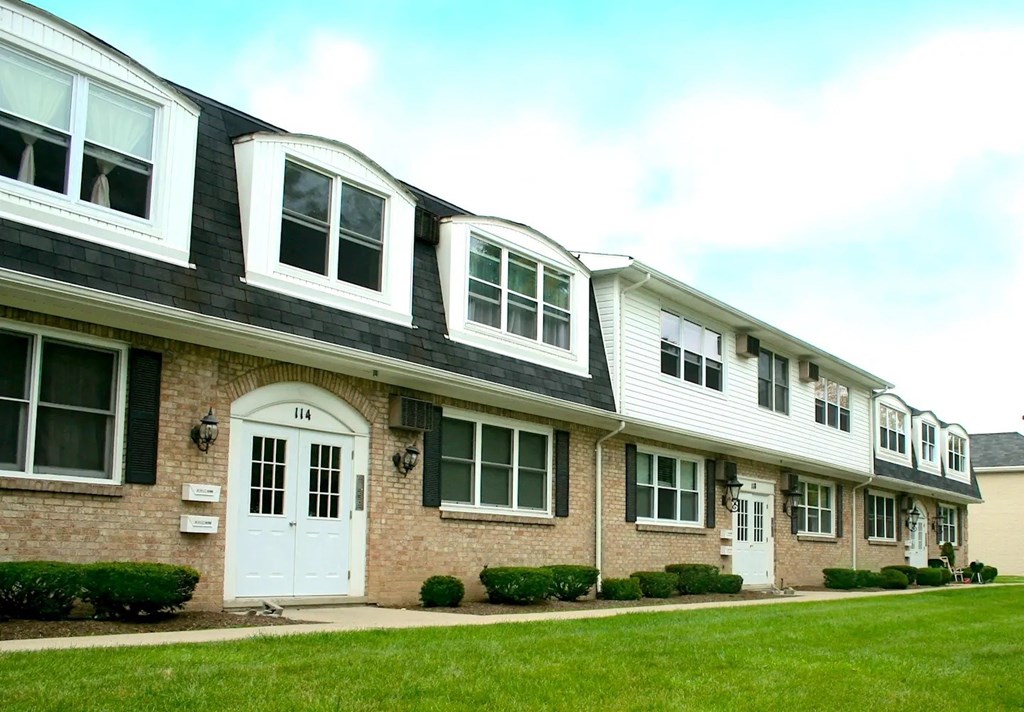 A row of houses with the first one having a white door.