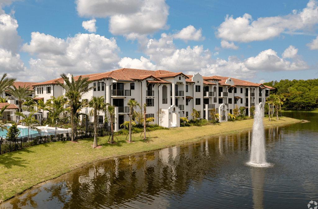 a large pond with a fountain in front of a building