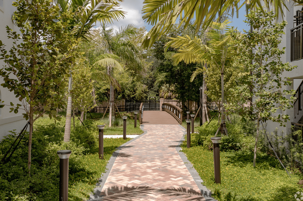 a wooden bridge over a brick path in a park