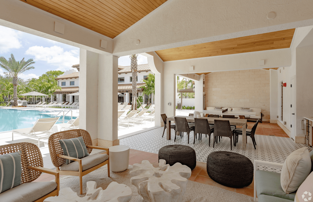 a living room and dining area with a pool in the background