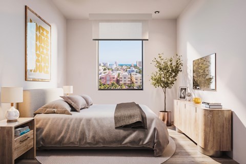 A bedroom with a large bed and a view of the city through the window.