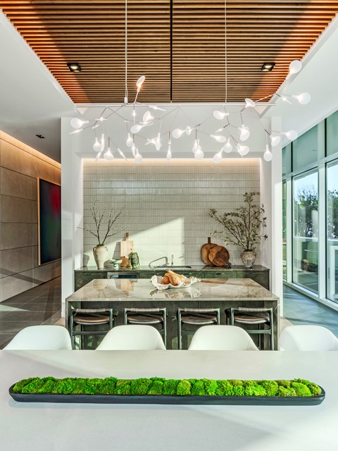A modern dining room with a long table and chairs.
