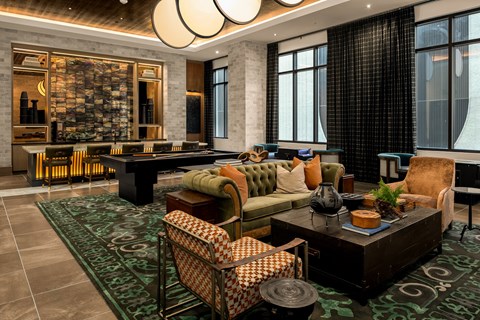 A living room with a green rug and a brown coffee table.