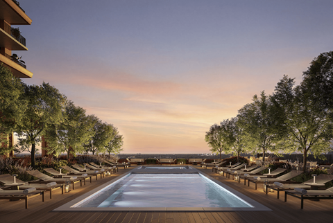 A long pool surrounded by lounge chairs and trees.