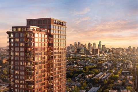 A tall red building stands in the foreground of a cityscape.