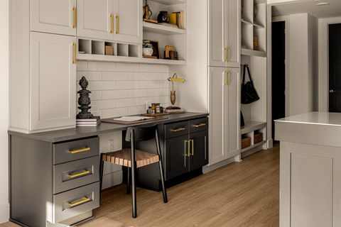 A kitchen with black and white cabinets and a wooden floor.