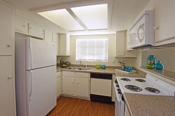 a white kitchen with a stove and a refrigerator