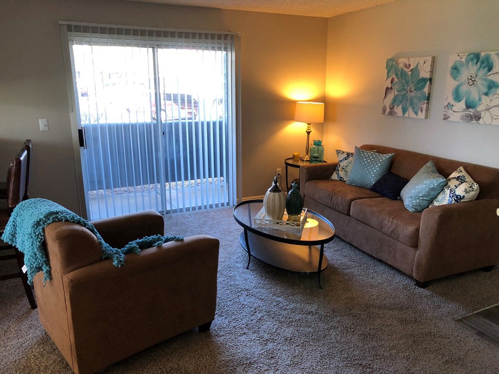 a living room with couches and a table and a window