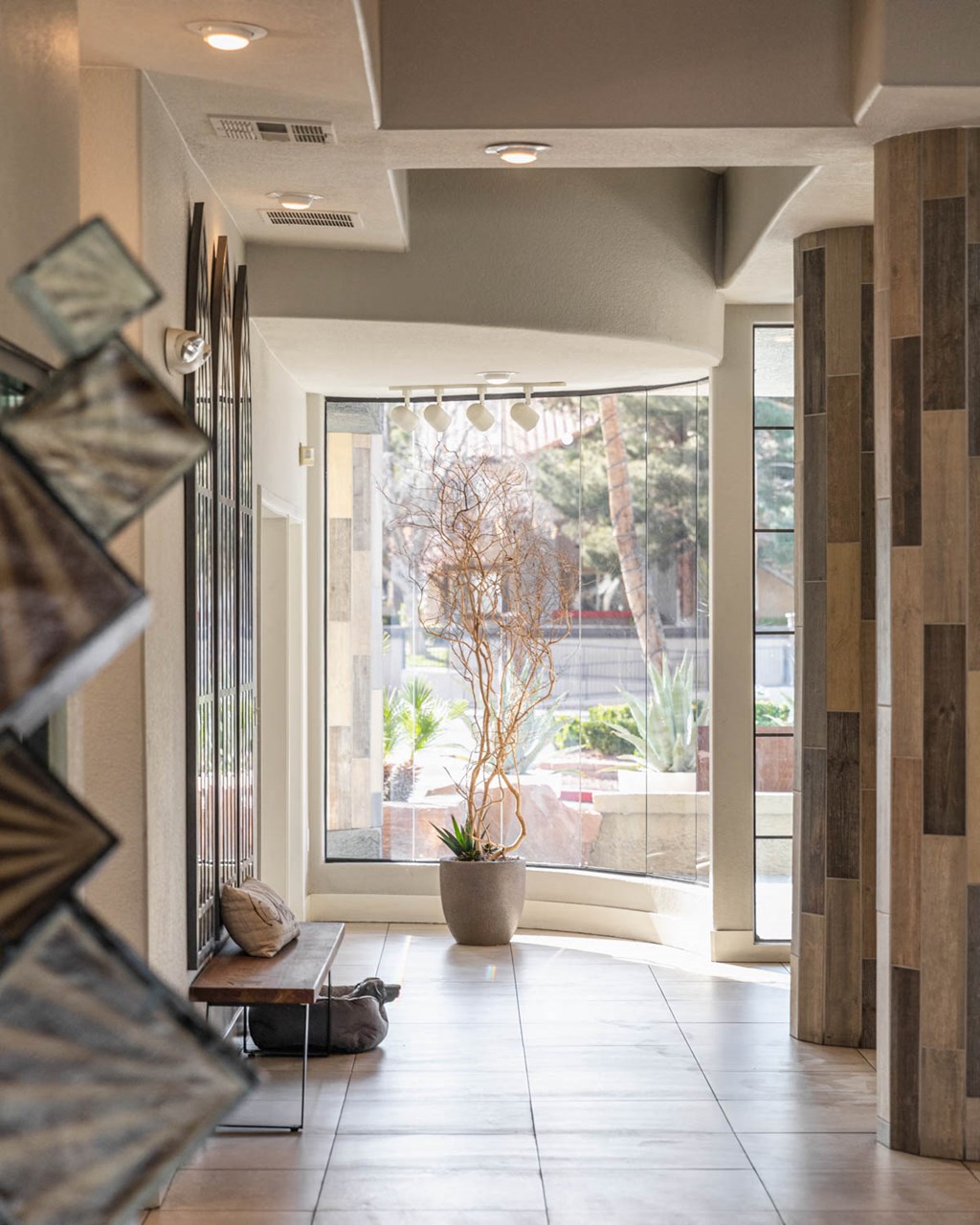 a hallway with a large window and a potted plant