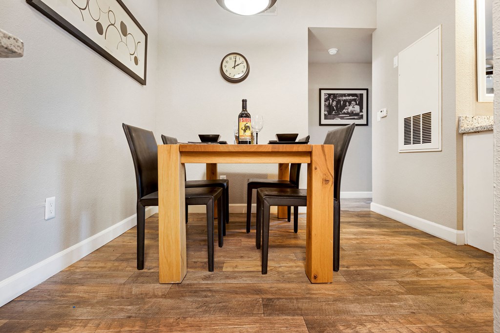a dining room with a table and chairs and a bottle of wine