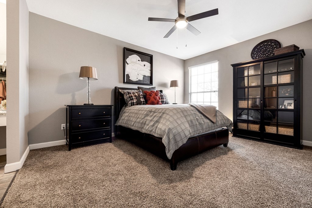 a bedroom with a bed and a ceiling fan