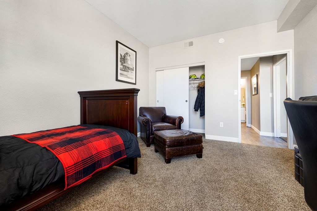 a bedroom with a bed and a chair and a closet