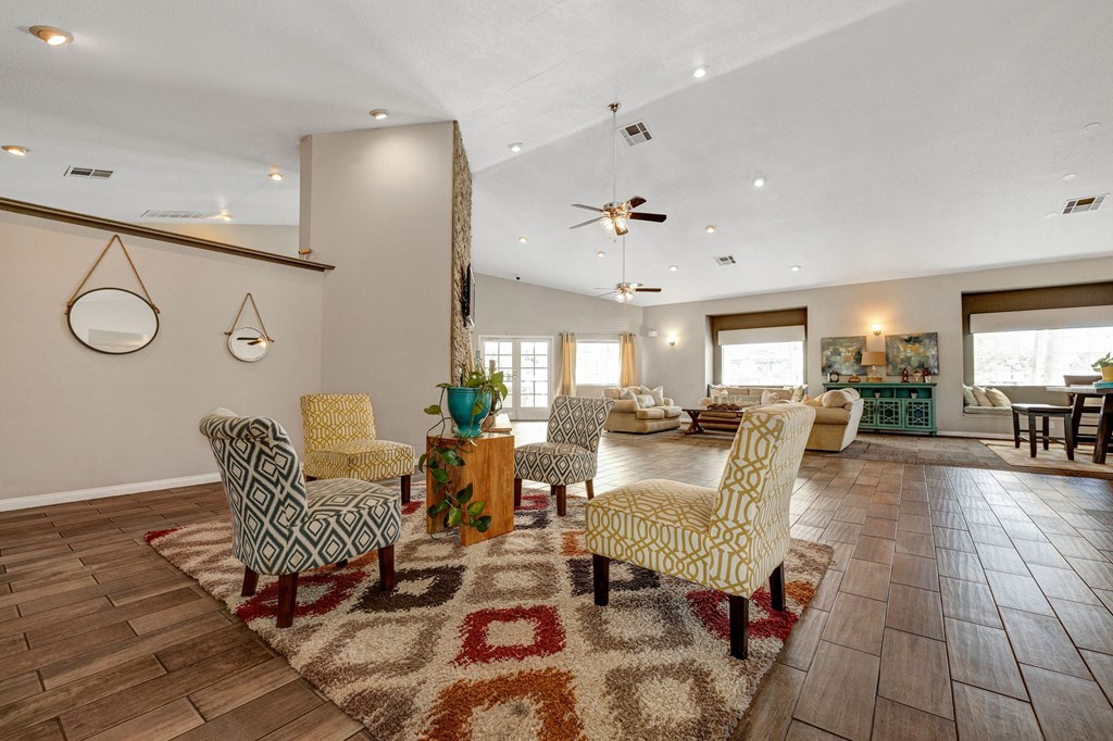a living room with chairs and a rug