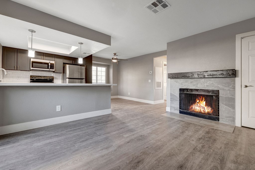 a living room with a fireplace and a kitchen