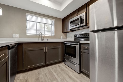 the kitchen of a home with stainless steel appliances and wooden cabinets