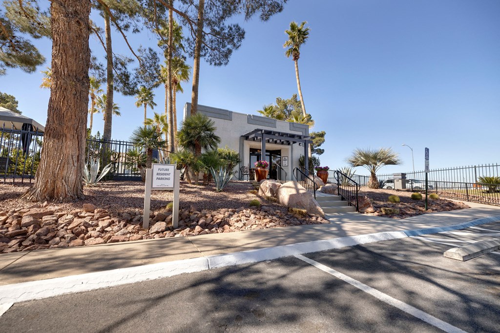 a building with palm trees and a sidewalk in front of it